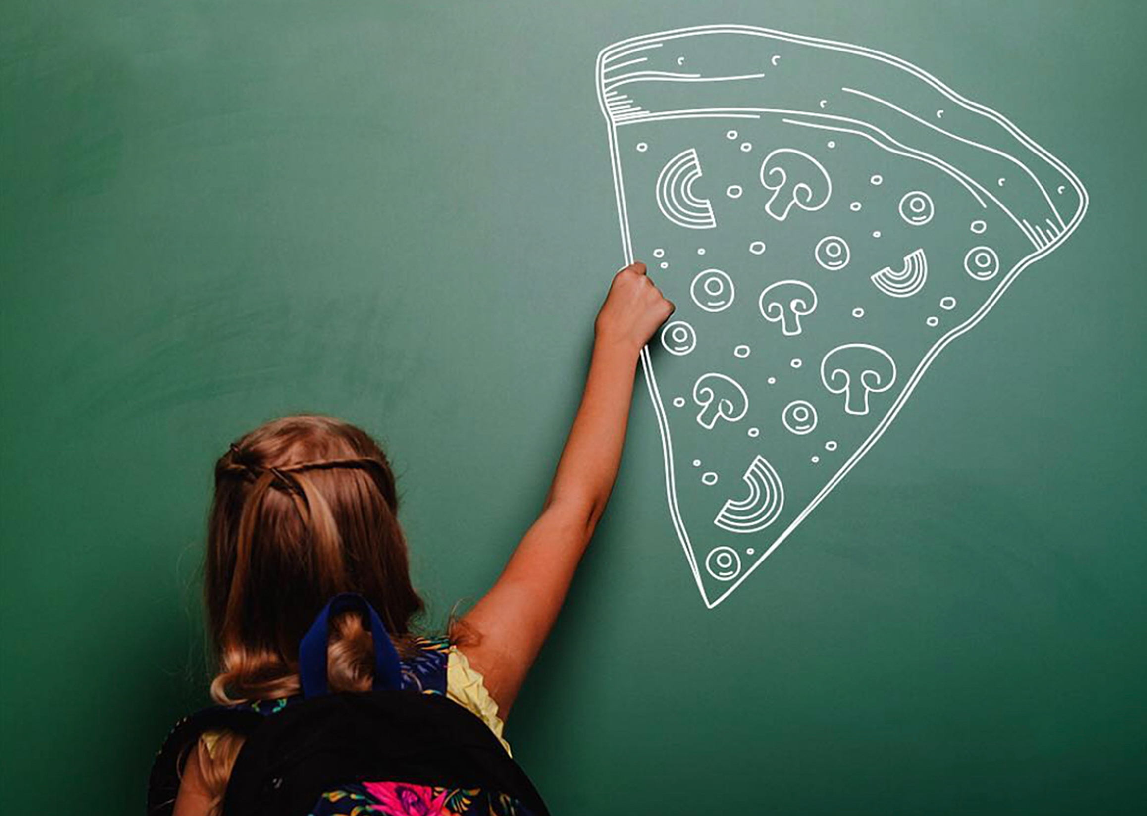 Image of school girl drawing pizza on chalkboard.