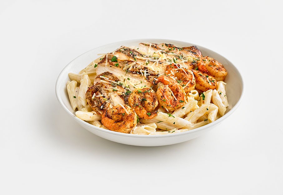Image of Chicken and Shrimp Pasta with penne noodles and cream sauce.