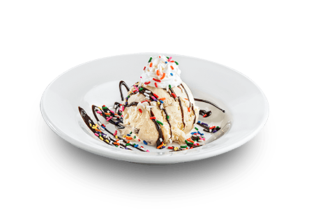 Image of vanilla ice cream with chocolate drizzle, sprinkles, and whipped cream. 