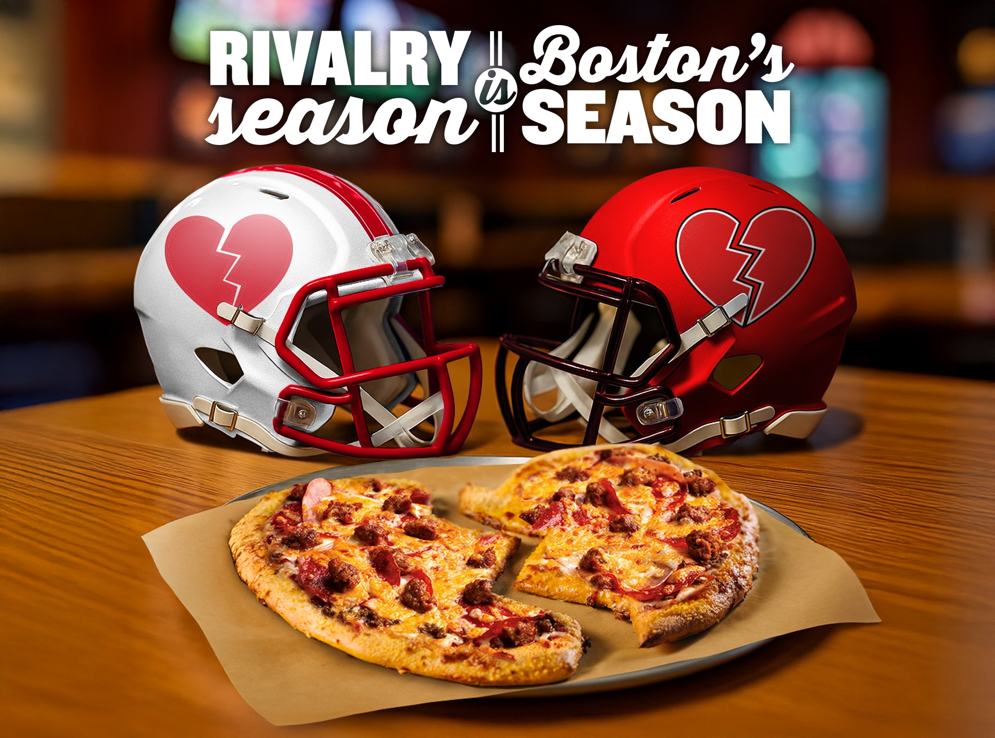 Photo of a broken heart pizza and two team helmets.